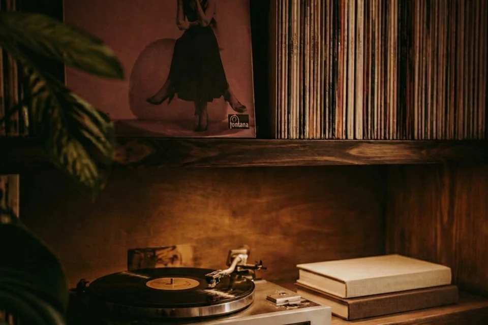 Warm-lit shelf of records and a turntable from the Suno Vinyl launch page · Suno, captured 22 Aug 2026